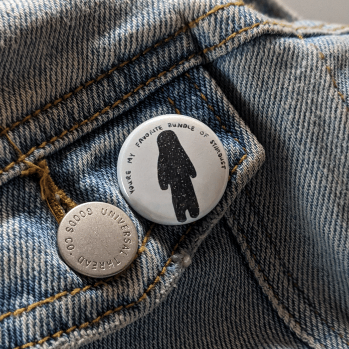 stardust button worn on a jean jacket